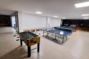 una habitación con mesas de ping pong en un edificio en Hermoso apt con BBQ en balcon y Vista a la piscina en Ricaurte