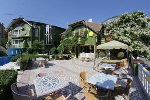 a patio with tables and chairs in front of a building at Villa Hera in Băile Herculane