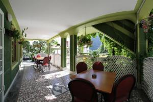 a room with a table and chairs on a patio at Villa Hera in Băile Herculane