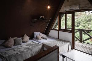 恩納村にあるLOGIN OKINAWA -wood-のベッド2台と窓が備わる客室です。