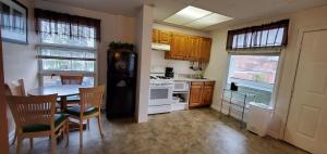 a kitchen with a table and chairs and a refrigerator at Lido Motel Lake George in Lake George