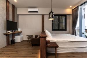 a bedroom with a bed and a tv and a couch at Marbordo B&B in Xiaoliuqiu