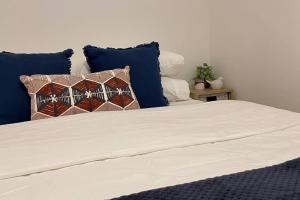 a bed with blue and white pillows on it at Kiama Palms on Collins in Kiama