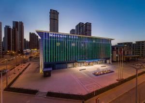 延安市にあるMercure Yan'an Downtownの都市にある緑のファサードを持つ建物