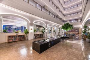 延安市にあるMercure Yan'an Downtownの植物が植えられた広いホールのある広いロビー