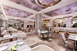 延安市にあるMercure Yan'an Downtownのテーブルと椅子のあるレストランのレンダリング