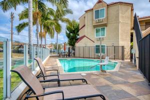 a swimming pool with chairs next to a building at Days Inn by Wyndham Carlsbad in Carlsbad
