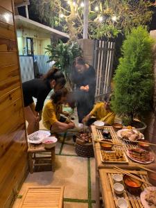 a group of people standing around a table with food at EUDORA HOUSE 2 in Da Thien +12 photos
