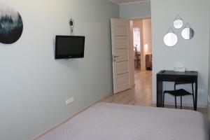 a bedroom with a bed and a desk and a television on a wall at Амурский бульвар 5, Семейные Апартаменты в районе набережной in Khabarovsk