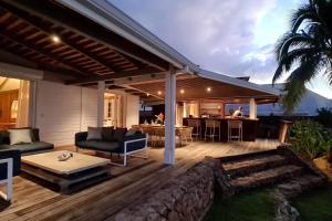 eine Terrasse mit einem Tisch und Stühlen sowie ein Haus in der Unterkunft Villa Oona in Maharepa