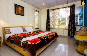 een slaapkamer met een groot bed en een raam bij LivingStone Hilltop Cottage in Bhowāli
