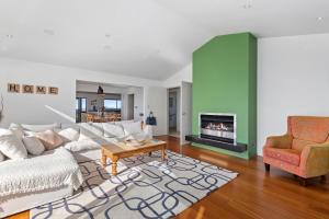 a living room with a couch and a fireplace at Tutukaka Vista - Tutukaka Holiday Home in Tutukaka