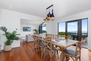 een eetkamer en een woonkamer met een tafel en stoelen bij Tutukaka Vista - Tutukaka Holiday Home in Tutukaka