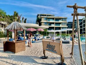 a sign on the beach with a resort in the background at Hua Hin VERANDA BEACHFRONT Living in Hua Hin