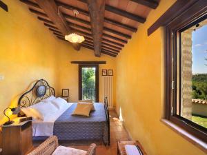 a bedroom with a bed and a large window at Belvilla by OYO Il Rigogolo in SantʼAngelo in Pontano