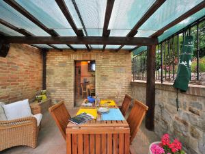 a patio with a table and chairs and a roof at Belvilla by OYO Il Rigogolo in SantʼAngelo in Pontano