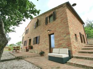 a brick building with a couch in front of it at Belvilla by OYO Il Rigogolo in SantʼAngelo in Pontano