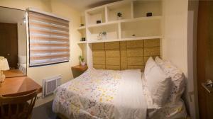 1 dormitorio con cama, escritorio y ventana en 2 Bedroom Condo Unit Fully Furnished, en Manila