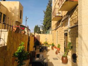 an alley with tables and potted plants in a building at St Thomas Home's Guesthouse - Jerusalem in Jerusalem