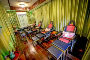 un gruppo di sedie e tavoli in una stanza con tende di MRK Resort & Massage a Lopburi