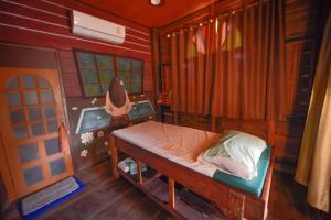 a small bedroom with a bed in a house at MRK Resort & Massage in Lop Buri