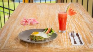 un plato de comida y una bebida en una mesa en Abhirama Villas by Supala, en Ubud