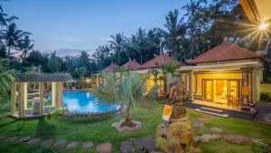 a villa with a garden and a swimming pool at Abhirama Villas by Supala in Ubud