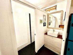 
a bathroom with a mirror, sink, and toilet at Nomads Noosa in Noosa Heads
