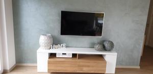 a white console table with a tv on a wall at Ferienwohnung Selina in Bachem