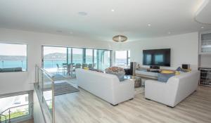 a living room with two white couches and a television at THE VIEW LANGEBAAN LAGOON VILLA WITH HEATED POOL and SOLAR ENERGY in Langebaan