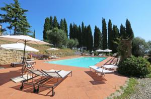 a swimming pool with lounge chairs and umbrellas at Agriturismo Macciangrosso Casale Piccolomini in Chiusi