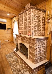 een open haard in een kamer met een houten muur bij Комплекс відпочинку GoldFіsh Сlub in Babintsy