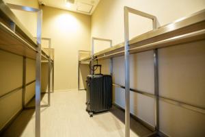 a suitcase walking down a hallway in an elevator at Cabin & Capsule Hotel J-SHIP Osaka Namba in Osaka