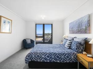 a bedroom with a bed and a view of the ocean at Apartment 11 Pacific Apartments in Lorne