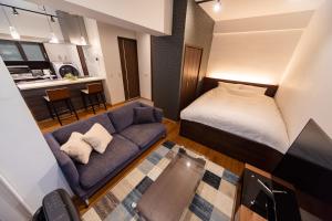 um pequeno quarto com uma cama e um sofá em NIYS apartments 03 type em Tóquio