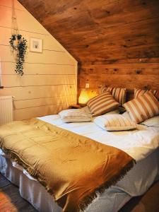a large bed in a room with a wooden wall at Cabana Khaliope in Floroaia Mică +44 photos