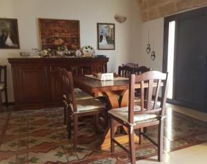 ein Esszimmer mit einem Holztisch und Stühlen in der Unterkunft LA DIMORA DI PALMIRA in Lucugnano