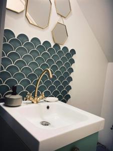 a bathroom sink with a black and white patterned wall at Cabana Khaliope in Floroaia Mică +44 photos