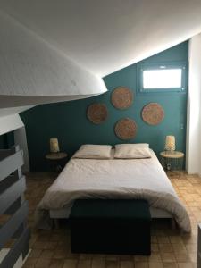 a bedroom with a bed and a blue wall at Cosy Lagune in Saint-Cyprien
