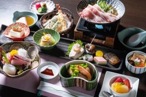 a table topped with different types of food in bowls at Mount View Hakone in Hakone