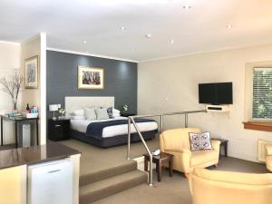 a hotel room with a bed and a living room at Briars Country Lodge in Bowral