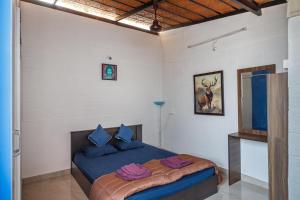 um quarto com uma cama com almofadas roxas em Cosy Penthouse with High speed wifi-UPS near WTC-IISC em Bangalore