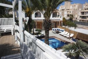 パロス岬にあるLove- SweethomeRooms Cabo de Palosのヤシの木とスイミングプール付きのバルコニー