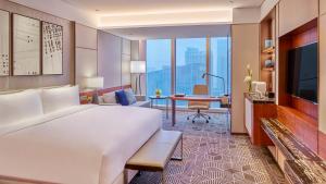 um quarto de hotel com uma cama grande e uma secretária em InterContinental Guangzhou Exhibition Center, an IHG Hotel - Free Canton Fair Shuttle Bus and Registration Counter em Guangzhou
