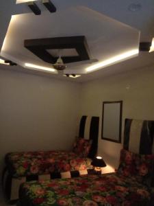 1 dormitorio con cama, sofá y techo en New Taj Hotel en Lahore