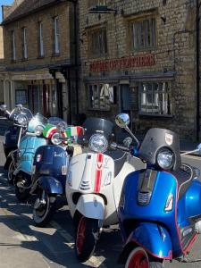 een rij scooters geparkeerd voor een gebouw bij The Plume of Feathers in Sherborne