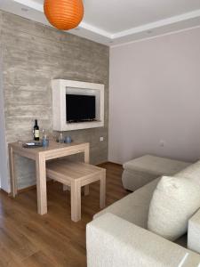 ein Wohnzimmer mit einem Tisch und einem Sofa in der Unterkunft ApartmaniZvezdara in Zvezdara