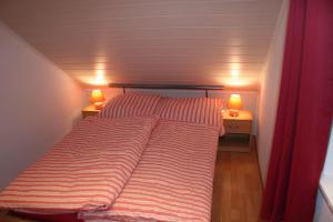 a bed in a small room with two lamps at Haus-Maria-Magdalena in Bad Lauterberg +12 photos