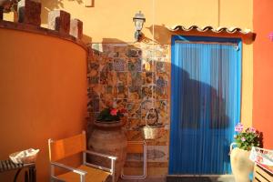Habitación con puerta azul y pared de piedra. en Duca di Castelmonte en Trapani