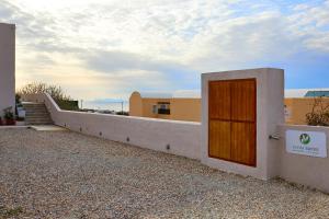 a building with a wooden door on the side of it at Alyvia Suites in Oia